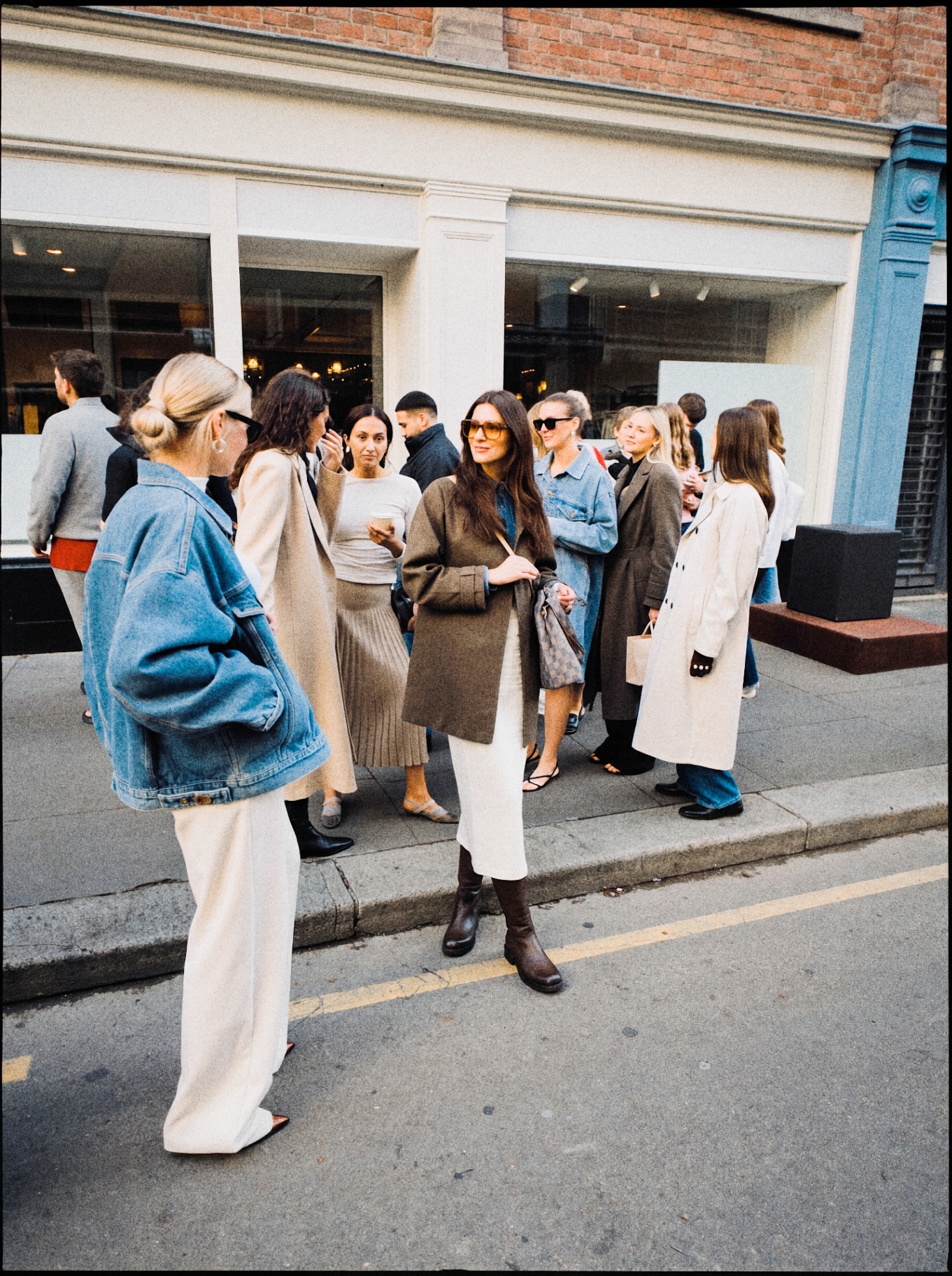 Group of stylish women gathering outside a contemporary storefront